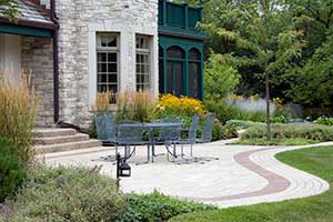 Combining concrete pavers with a ribbon of brick creates a sense of enclosure for this outdoor dining space in Bannockburn.