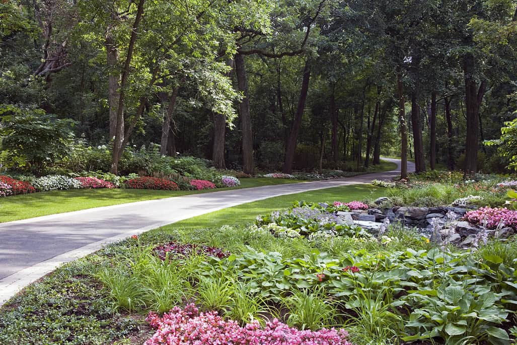 Van Zelst, Inc. Residence, Lake Geneva Incorporating a variety of colors, textures and heights, generous plantings and natural stone add visual interest beneath the trees. The winding entry drive is now a beautiful welcome for the homeowners and arriving guests.