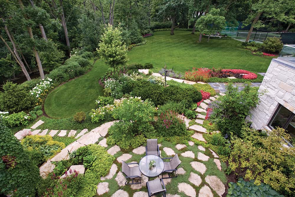 Van Zelst Northbrook Bluestone and fieldstone work together to complement the stone used in the home's exterior. Adding variety and color to the plantings brings out the colors in the facade and creates greater visual excitement.